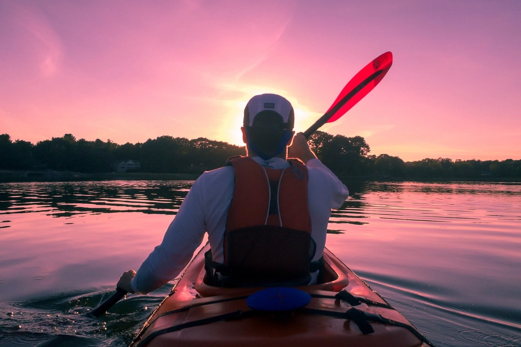 Kayaker paddling on calm open water